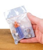 Hand hält den originalverpackten Storz & Bickel Kapselbehälter mit mehreren Dosierkapseln in einer durchsichtigen Tüte.