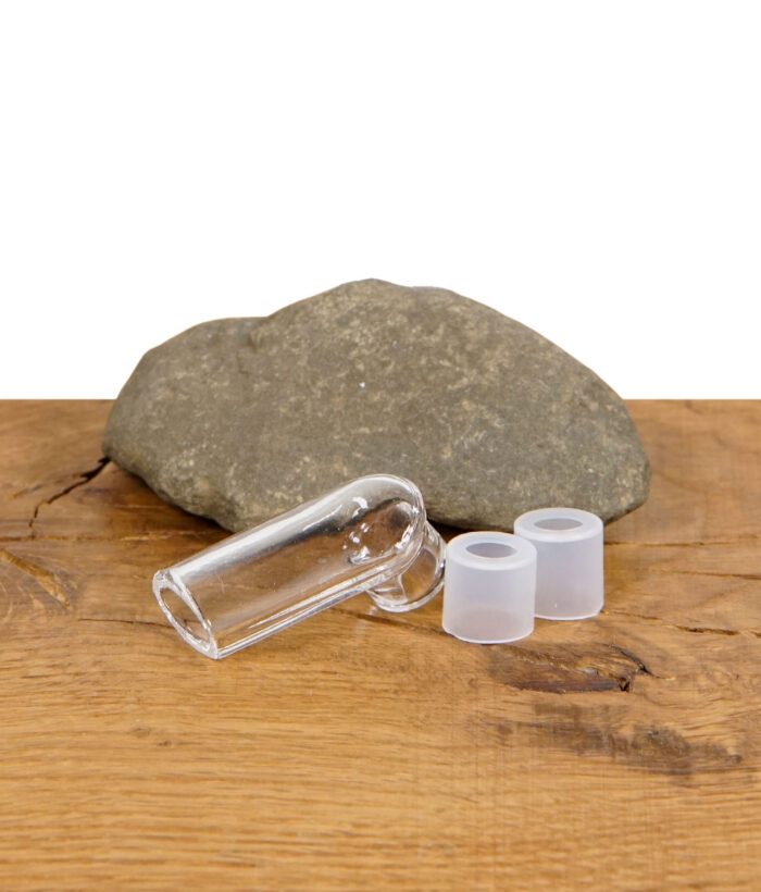 Glasaufsatz mit zwei Silikonringen auf einem Holztisch, im Hintergrund ein Stein.