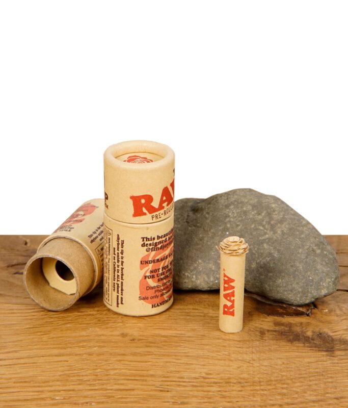 RAW Rose Tip – vorgerollter Filter mit kunstvoller Rosenspitze in umweltfreundlicher Kartonverpackung auf Holztisch mit Stein.