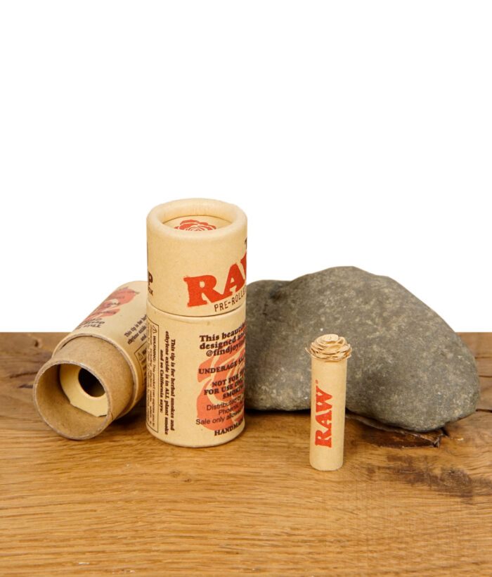RAW Rose Tip – vorgerollter Filter mit kunstvoller Rosenspitze in umweltfreundlicher Kartonverpackung auf Holztisch mit Stein.