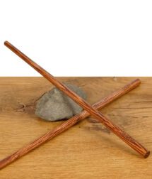 Zwei RAW Wooden Pokers – lange Holztamper für Cones, gekreuzt auf einem Stein liegend, präsentiert auf Holztisch.