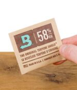 Boveda 58% Feuchtigkeitspack – in der Hand gehalten, zeigt das Logo und die Feuchtigkeitskontrolle für eine optimale Lagerung.