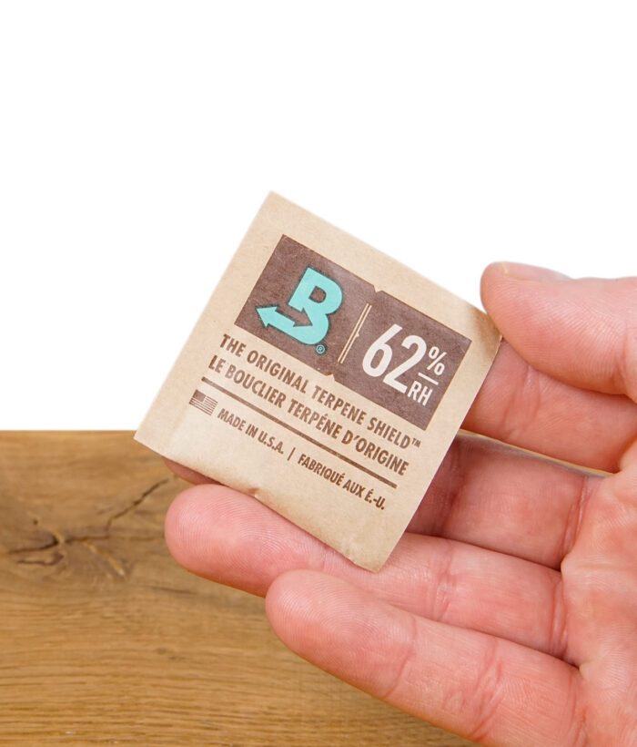 Boveda 62% Feuchtigkeitspack – in der Hand gehalten, zeigt das Logo und die Feuchtigkeitskontrolle für Kräuterlagerung.