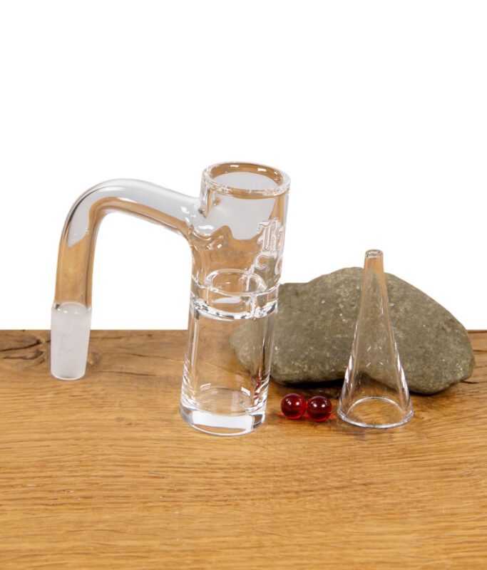 Komplettes Set aus Glasbanger, Terp Pearls und Einfülltrichter, arrangiert auf einem Holztisch mit Stein.