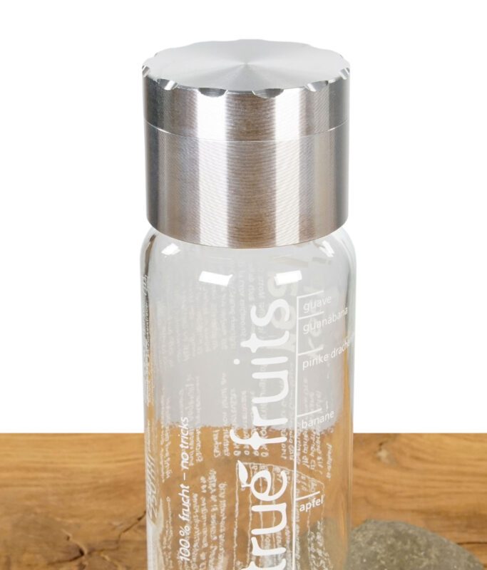 Nahaufnahme des True Fruits Grinders als Deckelaufsatz auf einer True Fruits Flasche.