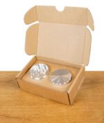 Geöffnete Verpackung mit True Fruits Grinder, Deckel und Mahlwerk sichtbar.