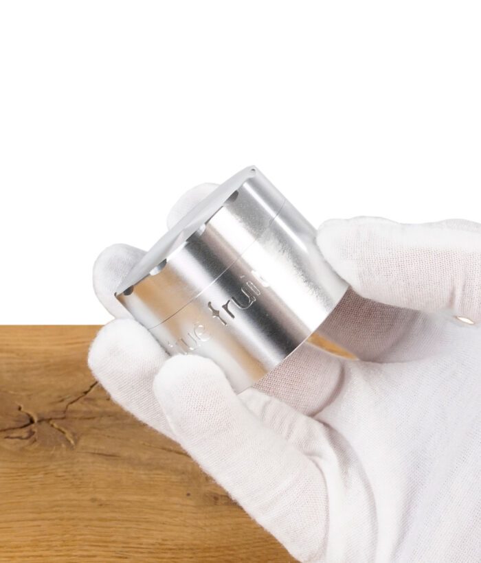 True Fruits Grinder wird von einer Hand mit weißen Handschuhen gehalten