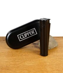 Clipper Jet Flame Feuerzeug in Schwarz mit schwarzem Etui auf einem Holztisch.
