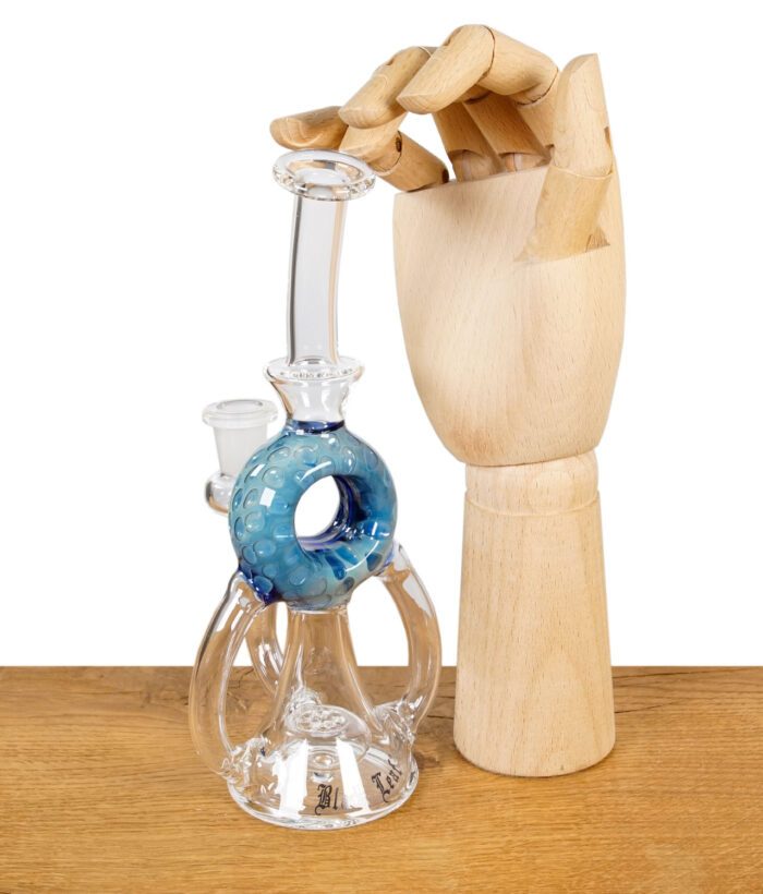 Glaspfeife mit blauer Perkolator-Kammer, daneben eine Holzhand zur Größenreferenz.