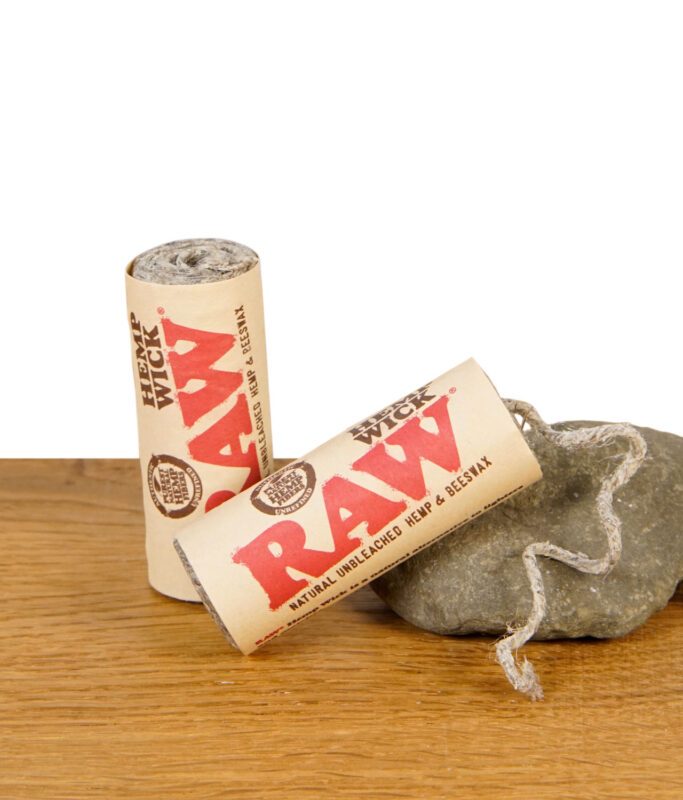 RAW Hemp Wick Rolle aus naturbelassenem Hanf und Bienenwachs auf Stein und Holztisch.