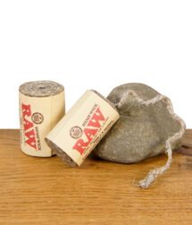 Zwei RAW Hemp Wick Rollen aus Hanf und Bienenwachs auf Stein und Holztisch arrangiert.