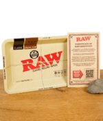 RAW Classic Mini Rolling Tray mit Echtheitszertifikat auf Holztisch neben einem Naturstein.