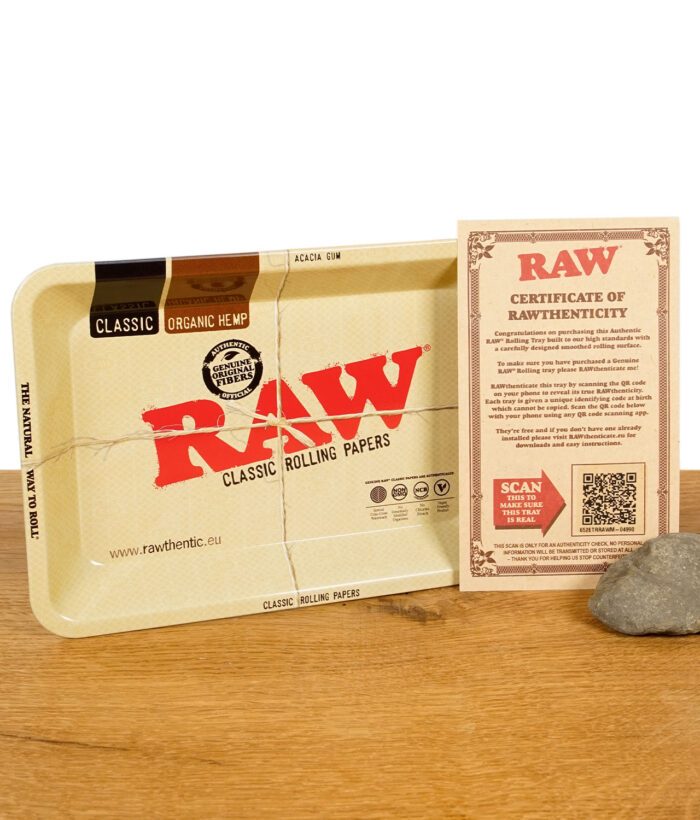 RAW Classic Mini Rolling Tray mit Echtheitszertifikat auf Holztisch neben einem Naturstein.