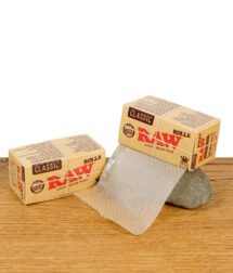 RAW Classic Rolls Kingsize Slim – ungebleichte Endlos-Rollpapierrolle mit Verpackung auf Holztisch.