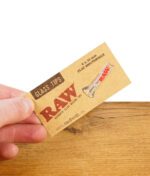 RAW Glass Tip Flat Mouthpiece, von Hand präsentiert mit Verpackung auf Holztisch.