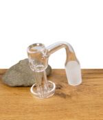 Black Leaf Banger aus Glas mit breitem Auffangring und gebogenem Hals auf Holzuntergrund und Stein.