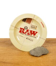 RAW Aschenbecher im Rolling Paper Design mit klassischem Logo auf Holztisch