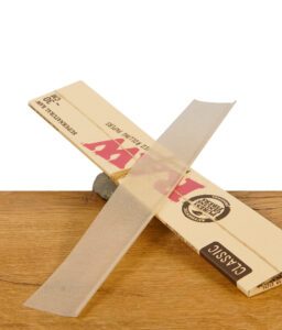 RAW Supernatural Rolling Paper Classic, entnommen aus der Verpackung auf Holztisch