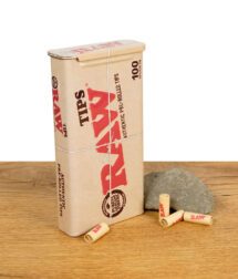 RAW Tin Metalldose mit fertig gerollten Filtern auf einem Holzbrett vor weißem Hintergrund