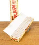 Geöffnete Packung RAW Organic Hemp Cones King Size 32er Pack mit mehreren vorgedrehten Cones auf Holztisch