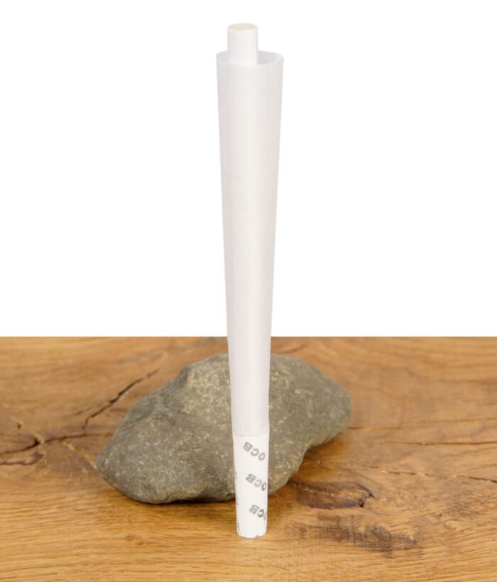 Ein einzelner OCB Premium Cone Slim aus dem 3er Pack stehend auf Stein und Holztisch