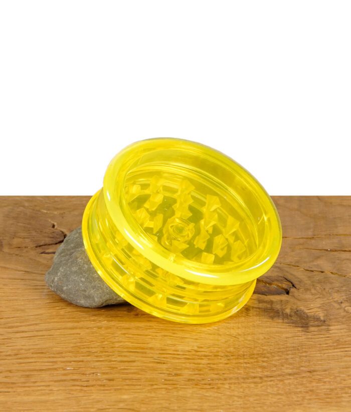 Black Leaf Grinder Acryl 60mm in Gelb auf Holztisch mit Stein