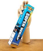 Juicy Super Wrap Tropical Verpackung in blauen Farbtönen, gehalten von einer Holzhand auf Holztisch