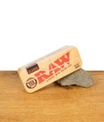 RAW Metal Tin Case 1 1/4 Size geschlossen, auf Stein platziert auf Holztisch