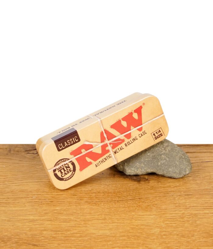 RAW Metal Tin Case 1 1/4 Size geschlossen, auf Stein platziert auf Holztisch