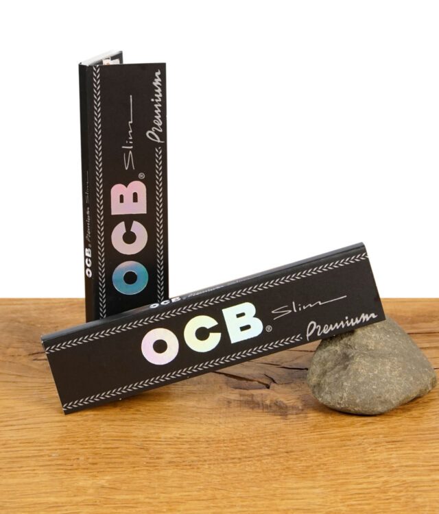 Zwei geschlossene Packungen OCB Premium Papers King Size Slim mit schimmerndem Logo auf schwarzem Hintergrund.