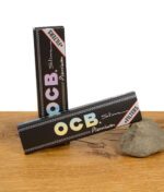 Zwei geschlossene Packungen OCB Premium Slim + Filters mit holografischem Logo und Filter-Hinweis auf schwarzem Design.