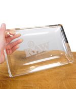 Hand hält das RAW Crystal Glass Rolling Tray – edles Glas-Rollbrett mit RAW-Logo in hochwertiger Verarbeitung.