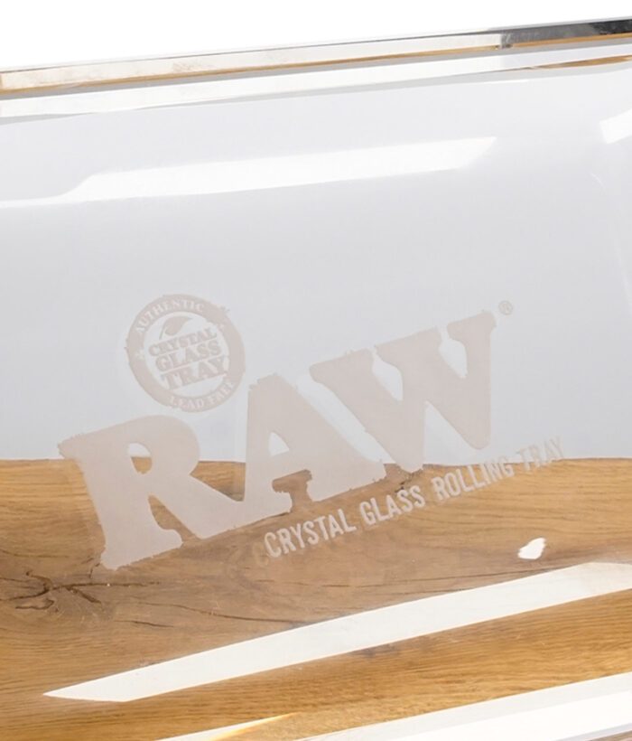 Detailaufnahme des RAW Crystal Glass Rolling Trays mit eingraviertem Logo auf transparentem Bleikristallglas.