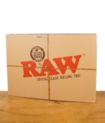 Verpackung des RAW Crystal Glass Rolling Trays aus braunem Karton mit rotem Logo und Bindfaden im RAW-Stil.