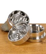 Geöffneter Black Leaf Grinder aus Metall zeigt das robuste Mahlwerk mit diamantförmigen Zähnen.