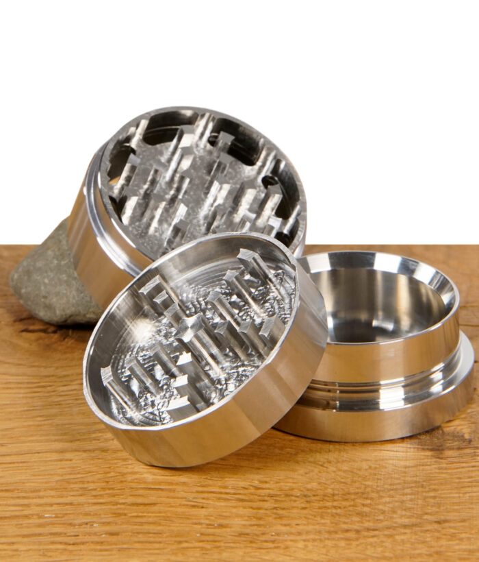 Geöffneter Black Leaf Grinder aus Metall zeigt das robuste Mahlwerk mit diamantförmigen Zähnen.