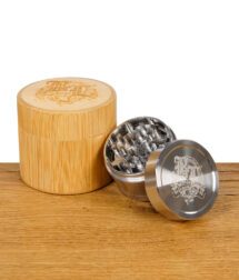 Komplett geöffneter Black Leaf Grinder neben verschlossenem Bambusbehälter mit eingraviertem BL-Logo.