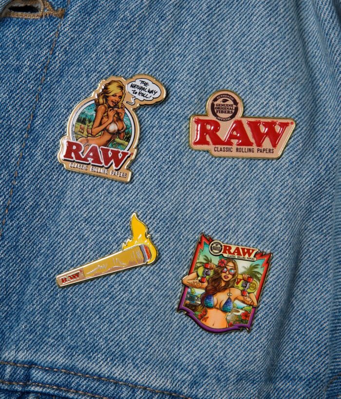 RAW Pins als Accessoire an einer Jeansjacke – bunte Motive für RAW-Fans