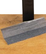 Schwarzes King Size Slim Rolling Paper von JaJa Noir, halb entfaltet auf Holztisch