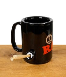 RAW Tasse mit Chillumfunktion befüllt mit Joint aufgestellt auf Holzfläche