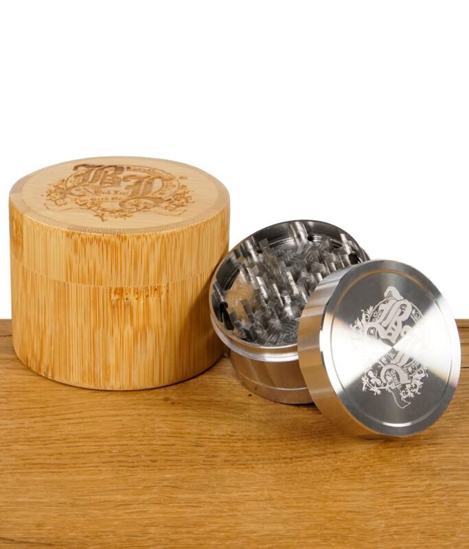 Black Leaf Edelstahlgrinder neben runder Aufbewahrungsbox aus graviertem Bambus