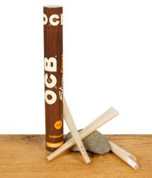 OCB Virgin Cones in brauner Papprolle mit drei ungefüllten Cones auf Holztisch