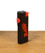 RAW Phoenix Feuerzeug mit geschlossenem Poker-Tool in Schwarz-Rot aufgestellt