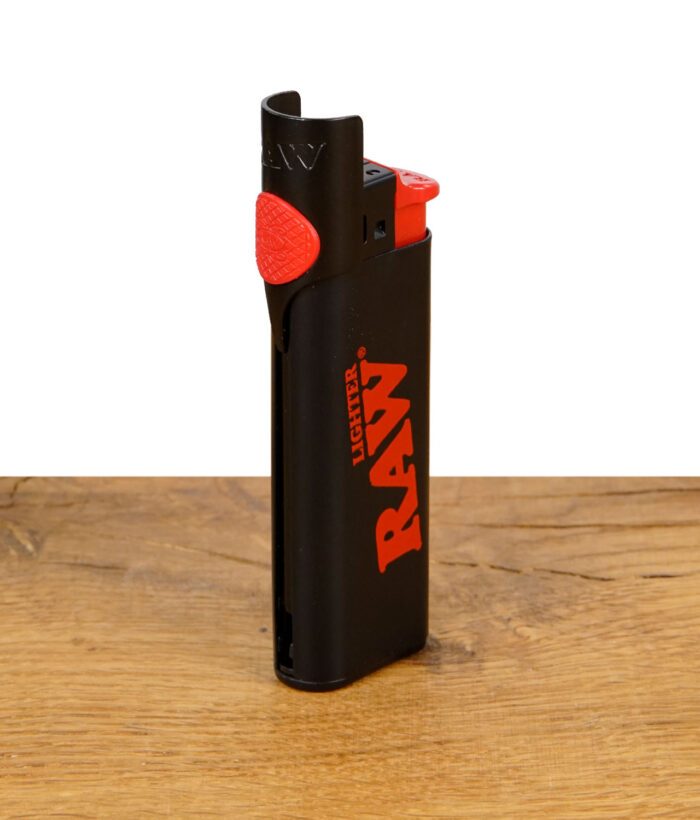 RAW Phoenix Clipper Lighter mit rotem Logo und integriertem Stopfwerkzeug auf Holztisch
