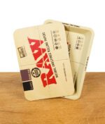RAW Rolling Tray Mini mit aufgelegtem magnetischen Deckel im klassischen RAW-Design – Tray leicht geöffnet dargestellt