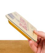 RAW Magnet-Cover Mini aus Metall mit gelbem Rand, seitlich in der Hand gehalten – flache, stabile Ausführung sichtbar