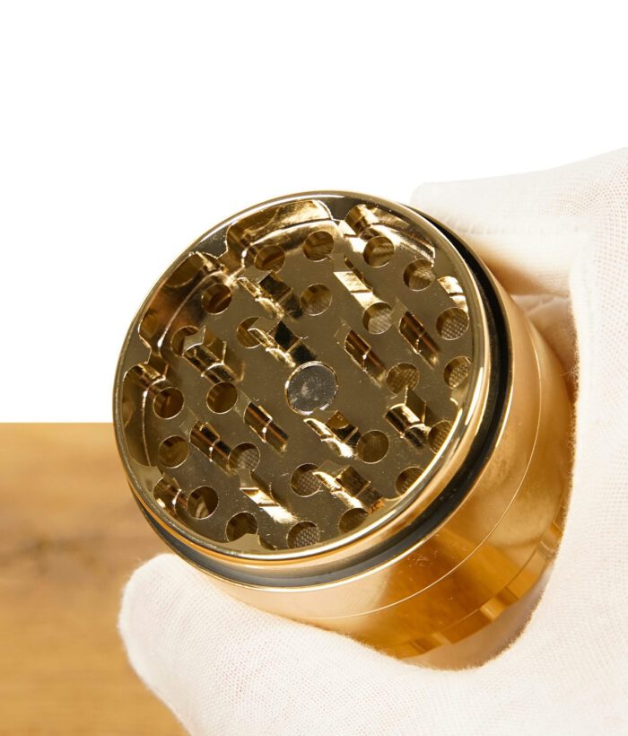 Nahaufnahme der Schleifkammer des RAW Ethereal Grinders mit diamantförmigen Zähnen – in weiß behandschuhter Hand