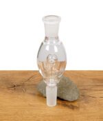 Black Leaf Flow Aktivkohleadapter aus Glas stehend vor einem Stein auf Holzfläche