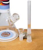 Lieferumfang der Blaze Beakerbong 7mm mit Farbverlauf inklusive Chillum und Glaskopf auf Holztisch