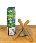 Zwei Cyclones Hemp Blunts Blue vor der geöffneten Verpackung mit Health-Warning auf Holztisch